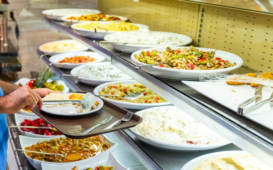 Man in Medical Scrubs Eating at a Buffet Style Cafeteria