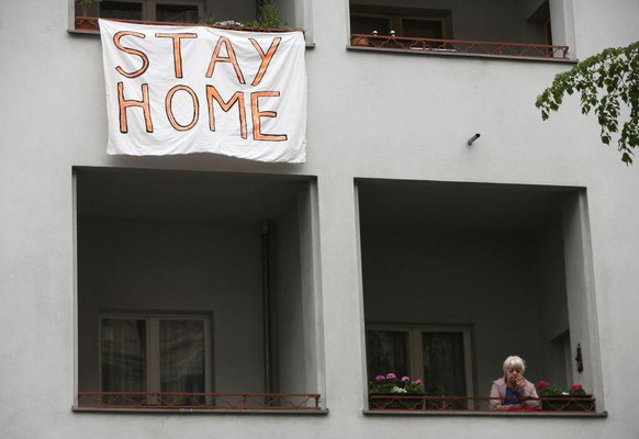 BERLIN, GERMANY - APRIL 25: A banner telling protesters to stay home hangs out of a window as activists demonstrate against restrictions on public life designed to stem the spread of the coronavirus,  ...