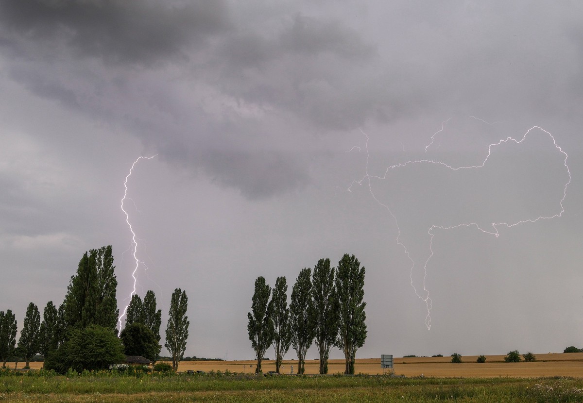 Blitzeinschlag Blitze eines Gewitters sind am Abend über einem Feld bei Bad Homburg zu sehen., Bad Homburg Hessen Deutschland *** Lightning strike Lightning from a thunderstorm can be seen in the even ...