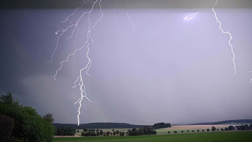 20.06.2023, Baden-Württemberg, Bartholomä: Ein Blitz zuckt bei einem Sommergewitter am abendlichen Himmel (Screenshot aus einem Video). (zu dpa «Weiterhin Gewitter und Starkregen im Südwesten») Foto:  ...