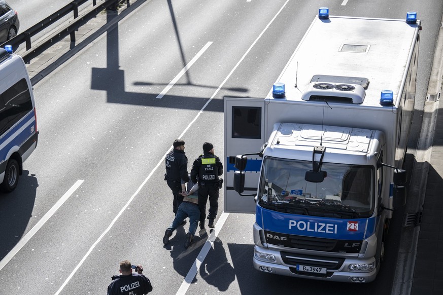 24.04.2023, Berlin: Zwei Polizisten tragen einen Aktivisten zum Gefangenentransport auf der A100. Am Montag will die Letzte Generation nach eigenen Angaben versuchen, die ganze Hauptstadt lahmzulegen. ...