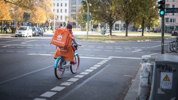 Ein Fahrradkurier der Firma Lieferando faehrt in Berlin Kreuzberg auf einer Kreuzung./ Foto: bildgehege Bringedienst Lieferando *** A bicycle courier of the company Lieferando drives in Berlin Kreuzbe ...