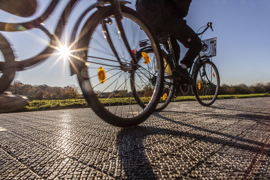 Fahrradfahrer auf einer Tour über die ausgelegten Solarplatten.