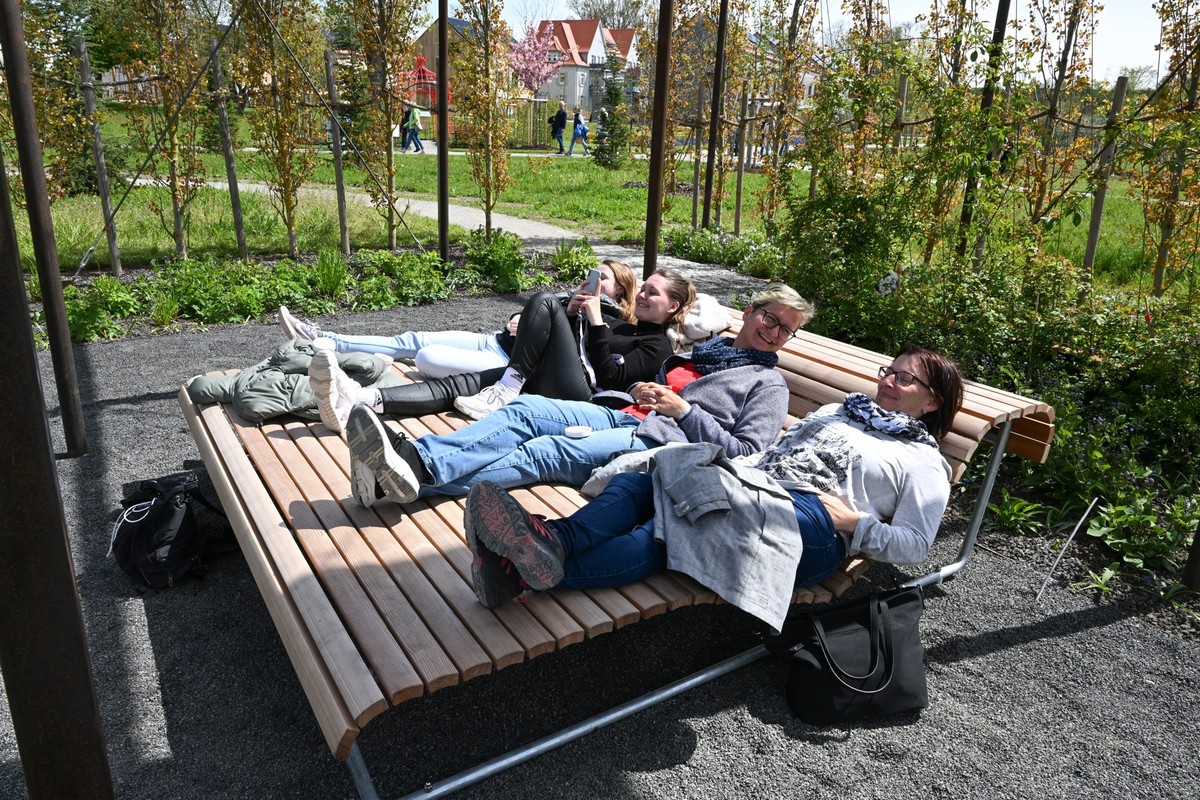 26.04.2024, Baden-Württemberg, Wangen im Allgäu: Besucher liegen nach der Eröffnung der Landesgartenschau in Wangen im Allgäu auf einer Ruhebank, die um geben von rankenden Pflanzen ist. Foto: Felix K ...