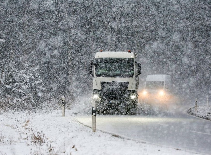 20.01.2023, Baden-Württemberg, Ittenhausen: Ein Lastwagen ist bei starkem Schneefall auf der L275 auf der Schwäbischen Alb unterwegs. Foto: Thomas Warnack/dpa +++ dpa-Bildfunk +++