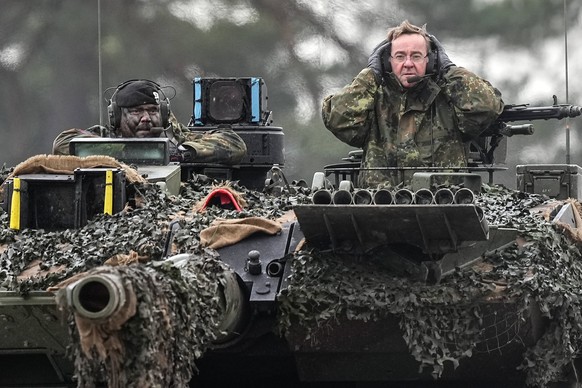 German Defense Minister Boris Pistorius, right, sits on a Leopard 2 tank at the Bundeswehr tank battalion 203 at the Field Marshal Rommel Barracks in Augustdorf, Germany, Wednesday, Feb. 1, 2023. Afte ...