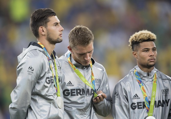 v.l. Torwart Eric OELSCHLAEGEL (Ölschläger), Nils PETERSEN, Serge GNABRY (GER) bei der Siegerehrung, sehen sich die Medaille, Silbermedaille, Silber, Fussball Maenner Finale, Brasilien (BRA) - Deutsch ...