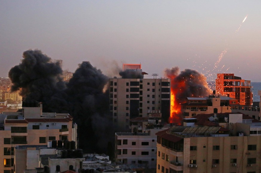 May 11, 2021, Gaza city, Gaza Strip, Palestinian Territory: Smoke rises from Hanadi tower after it was hit by Israeli air strikes amid a flare-up of Israeli-Palestinian violence, in Gaza City May 11,  ...