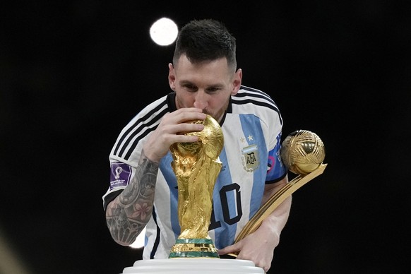 Argentina's Lionel Messi kisses the trophy after winning the World Cup final soccer match between Argentina and France at the Lusail Stadium in Lusail, Qatar, Sunday, Dec. 18, 2022. Argentina won 4-2  ...