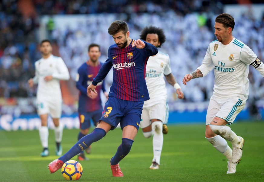 FC Barcelona Barca s defender Gerard Pique (L) in action against Real Madrid s defender Sergio Ramos during their Spanish Primera Division League s soccer match at the Santiago Bernabeu stadium in Mad ...