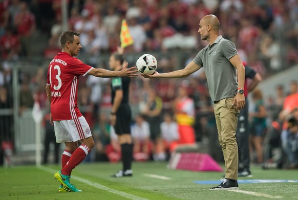 Manchester's head coach Pep Guardiola (front R) passes the ball to Munich's Rafinha during an international soccer friendly match between FC Bayern Munich and Manchester City at the Allianz Arena in M ...