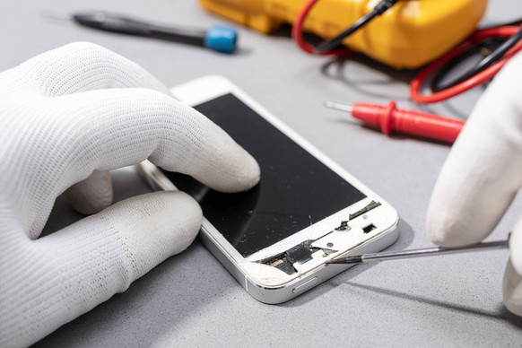 Technician hands working on broken smartphone for repair or replace new part on desk Technician hands working on broken smartphone for repair or replace new part on desk. Close up Copyright: xZoonar.c ...