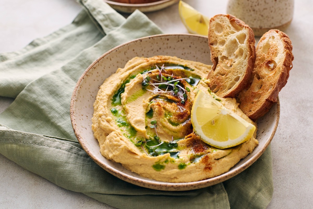 Delicious homemade hummus with lemon, paprika, olive oil and microgreens. Vegetarian Middle Eastern dish Delicious homemade hummus with lemon, paprika, olive oil and microgreens. Vegetarian Middle Eas ...