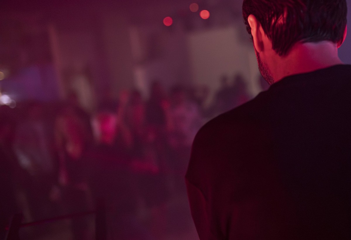 Rome, italy 4 may 2025: dj performing live electronic music with people dancing in nightclub, illuminated by red and purple lights Dj playing music at nightclub with blurred crowd in background Copyri ...