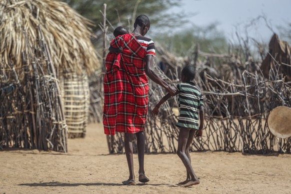 ARCHIV - 12.05.2022, Kenia, Lomoputh: Ein Vater hilft seinem unterern�hrten Sohn beim Gehen in der N�he ihrer H�tte in dem Dorf Lomoputh im Norden Kenias.(zu dpa: &quot;G7-Gipfel mit zwei Megathemen:  ...