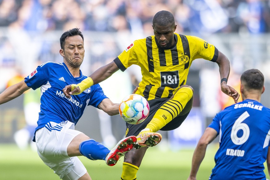 ARCHIV - 17.09.2022, Nordrhein-Westfalen, Dortmund: Fußball: Bundesliga, Borussia Dortmund - FC Schalke 04, 7. Spieltag, Signal-Iduna Park: Schalkes Maya Yoshida (l) und Dortmunds Anthony Modeste kämp ...