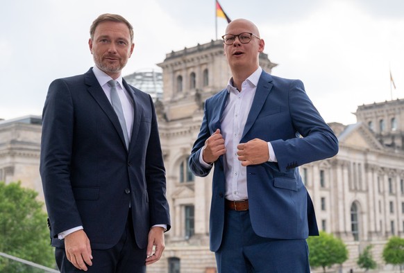 25.07.2021, Berlin: Christian Lindner (l), Parteivorsitzender der FDP, steht vor dem ARD-Sommerinterview auf der Terrasse des Marie-Elisabeth-L�ders-Hauses neben Matthias Dei�, deutscher Fernsehjourna ...