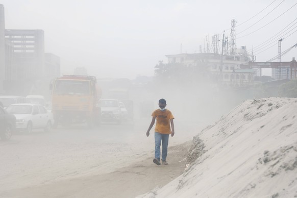 Heavy Pollution in Dhaka - Bangladesh Vehicles and motorcycles crossing a dusty road. Dust pollution reaches an alarming stage in Dhaka Men crossing a dusty road on August 20, 2022 in Dhaka, Banglades ...