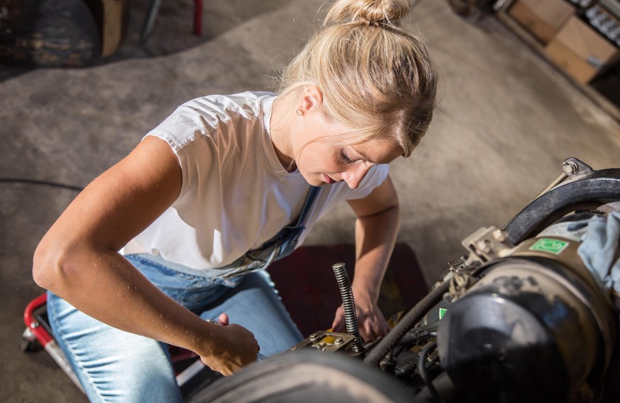 Bamberg, Deutschland 13. Oktober 2021: Eine Frau arbeitet in einem Handwerksbetrieb für Instandsetzung. Mit einem Steckschlüssel öffnet sie eine Schraube. Sie ist mit voller Freude und Spaß bei ihrer  ...