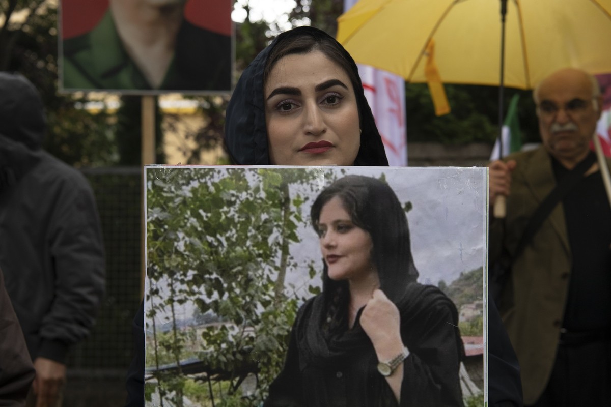 20.09.2022, Berlin: Bei einem Protest des Nationalen Widerstandsrates Iran (NWRI) vor der iranischen Botschaft in Berlin hält eine Frau ein Bild der verstorbenen Mahsa Amini in Händen. Die junge Frau  ...