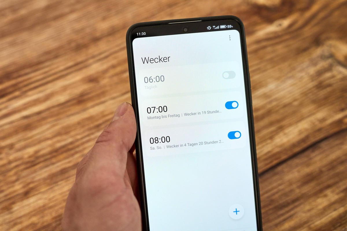 Germany - June 17, 2024: Smartphone or cell phone displays the alarm clock app. The alarm times 6, 7, 8 o clock are displayed. Concept for healthy sleep and getting up. *** Smartphone, bzw. Handy zeig ...