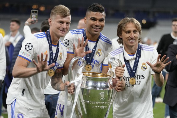 Real Madrid&#039;s Luka Modric, right, Real Madrid&#039;s Casemiro, center, and Real Madrid&#039;s Toni Kroos pose for a photograph with the trophy after winning the Champions League final soccer matc ...