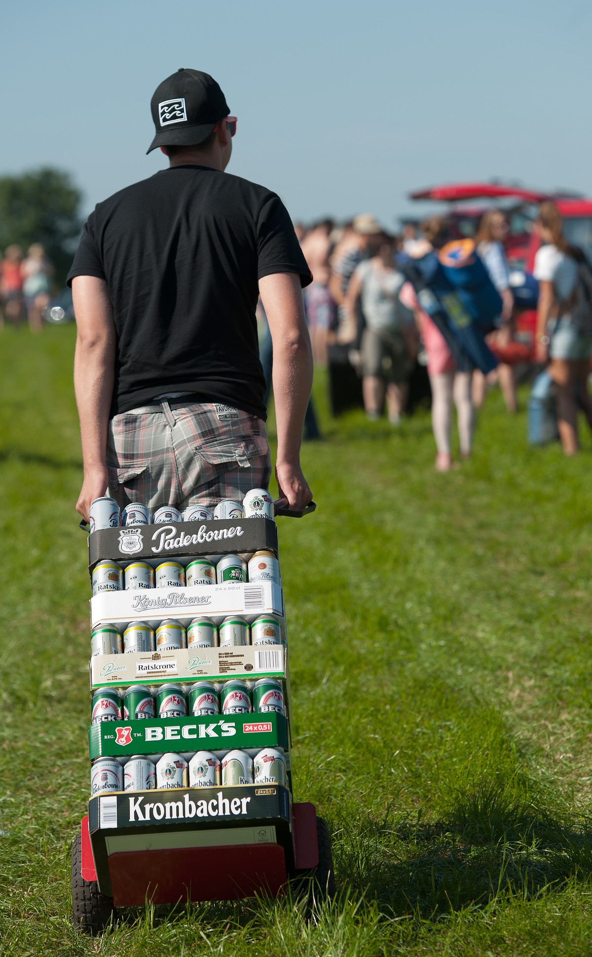 Ein Festivalbesucher zieht am 18.07.2013 in Nordholz (Niedersachsen) vor Beginn des Musikfestivals &quot;Deichbrand&quot; eine Sackkarre mit Bierdosen hinter sich her. Vom 18. bis 21.07.2013 treten na ...
