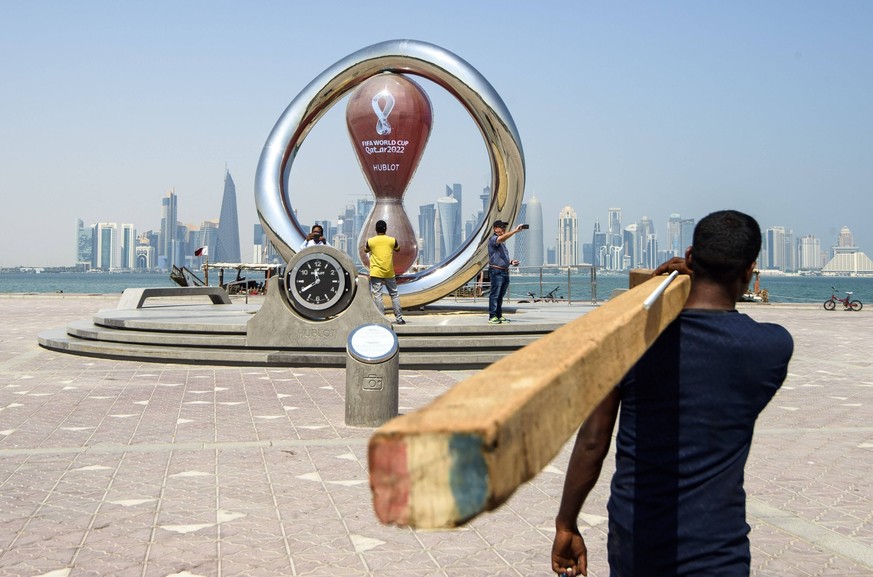 2022-10-05 11:39:42 Photo taken on 05 October 2022. People take photos in front of the Fifa World Cup 2022 Qatar countdown clock in Doha - Qatar. ahead of the FIFA 2022 World Cup football competition. ...