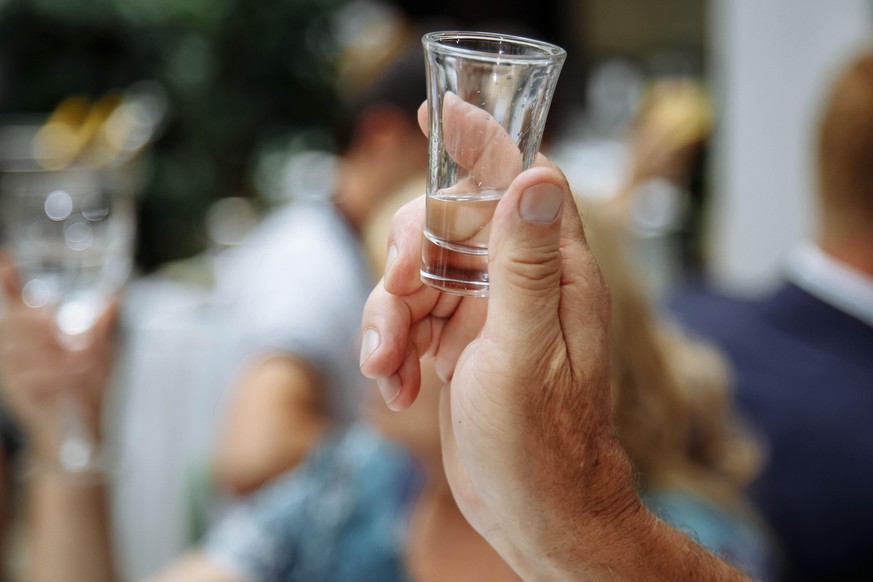 Man&#039;s hand holding a glass with vodka