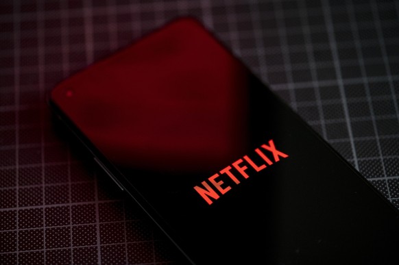 ARCHIV - 21.01.2022, Berlin: Auf dem Bildschirm eines Smartphones ist das Logo von Netflix zu sehen. Die Abonnenten-Zahlen bei Netflix sind nach Beginn des breiten Vorgehens gegen das Teilen von Passw ...