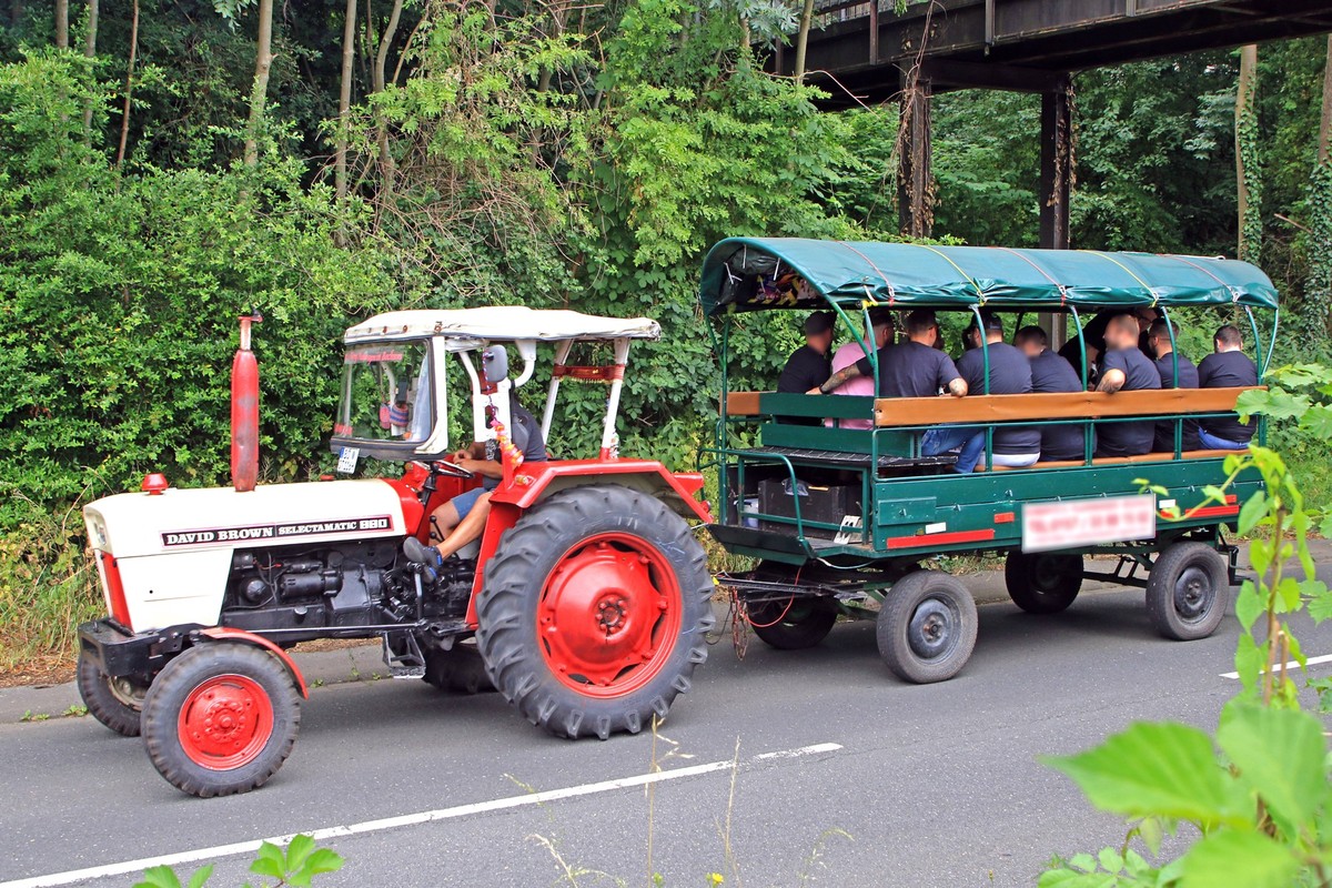 Party in einem Planwagen Ein Traktor zieht einen Planwagen, in dem sich eine Gruppe feiernder M�nner befindet. *** Party in a covered wagon A tractor pulls a covered wagon in which there is a group of ...