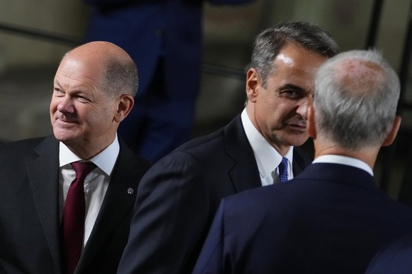 Germany&#039;s Chancellor Olaf Scholz, left, walks with Greece&#039;s Prime Minister Kyriakos Mitsotakis, center, after a group photo during meeting of the European Political Community at Prague Castl ...