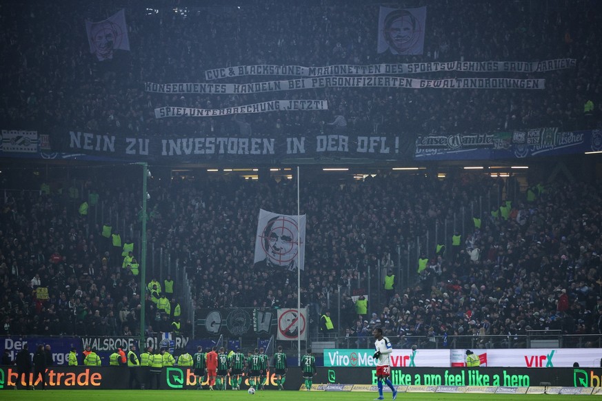 09.02.2024, Hamburg: Fußball: 2. Bundesliga, Hamburger SV - Hannover 96, 21. Spieltag, Volksparkstadion. Bei einem Protest der Fans von Hannover 96 wird ein Banner mit der Aufschrift &quot;Nein zu Inv ...