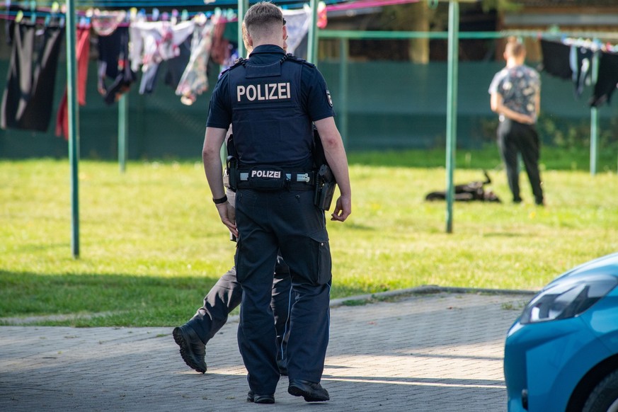 26.09.2023, Mecklenburg-Vorpommern, Pragsdorf: Polizisten stehen im Dorf. Nach dem gewaltsamen Tod eines sechsjährigen Jungen im Südosten Mecklenburg-Vorpommerns hat die Polizei einen 14-jährigen Tatv ...