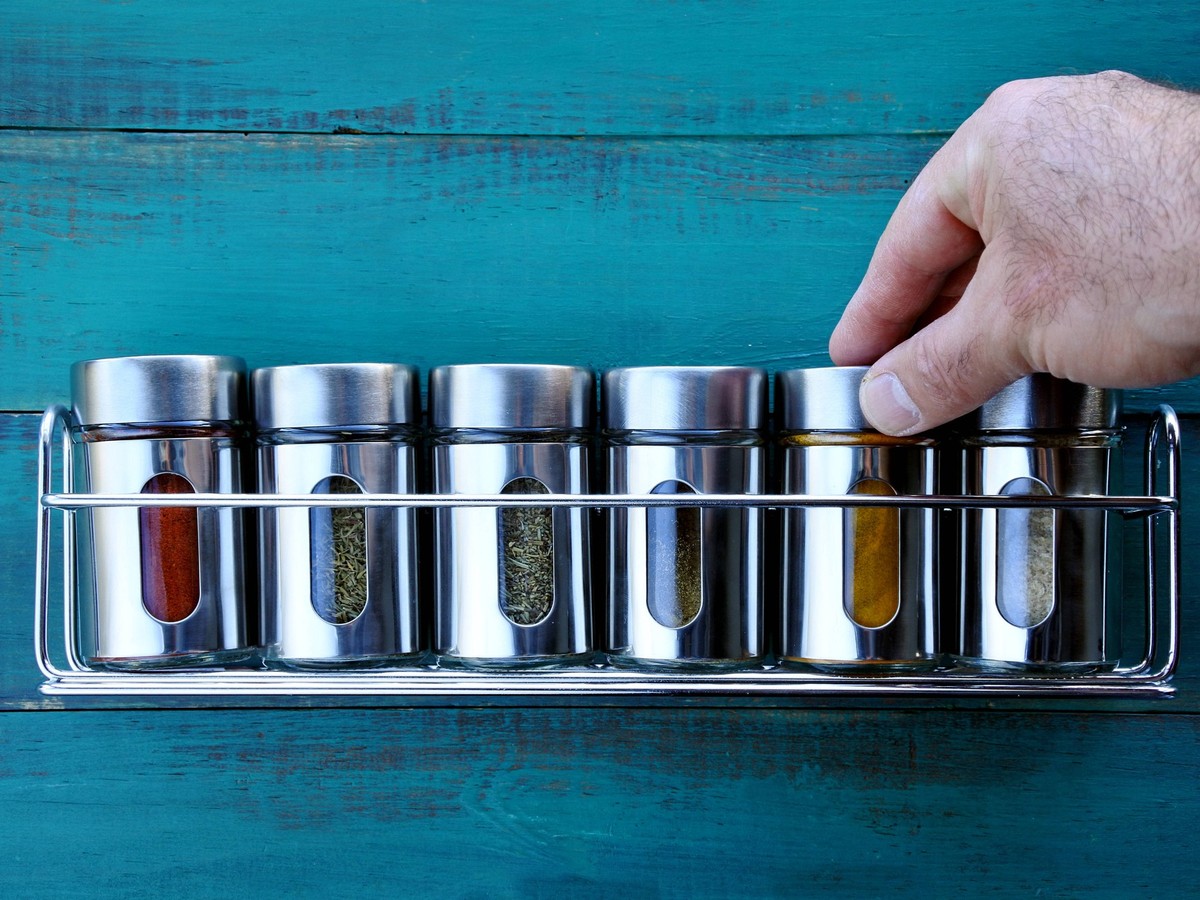 Chef hand returning spice into a spice rack Chef hand returning spice into a spice rack. Food background. copy space EDITORIAL USE ONLY Copyright: xx RafaelxBen-Ari/ChameleonsxEyex cecreative090516