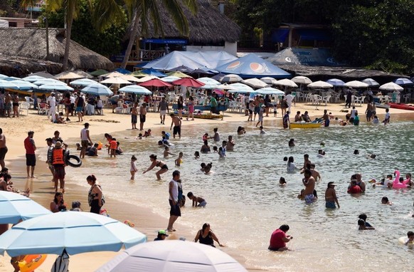 Tourists, mostly from Mexico City, enjoy Caleta Beach in the port of Acapulco in Guerrero state, Mexico, on March 19, 2021, amid the COVID-19 pandemic.  (Photo by Alfredo Estrela/AFP) (Photo by Alfredo Estrela/AFP) (Photo by Alfredo Estrela/AFP)