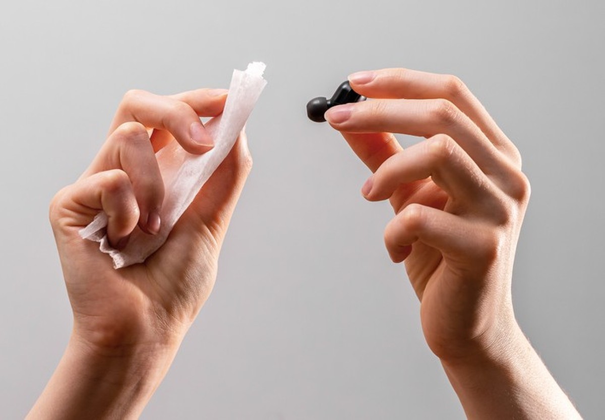 Hands cleaning earphones, earbuds with wet cloth, antibacterial wiper.