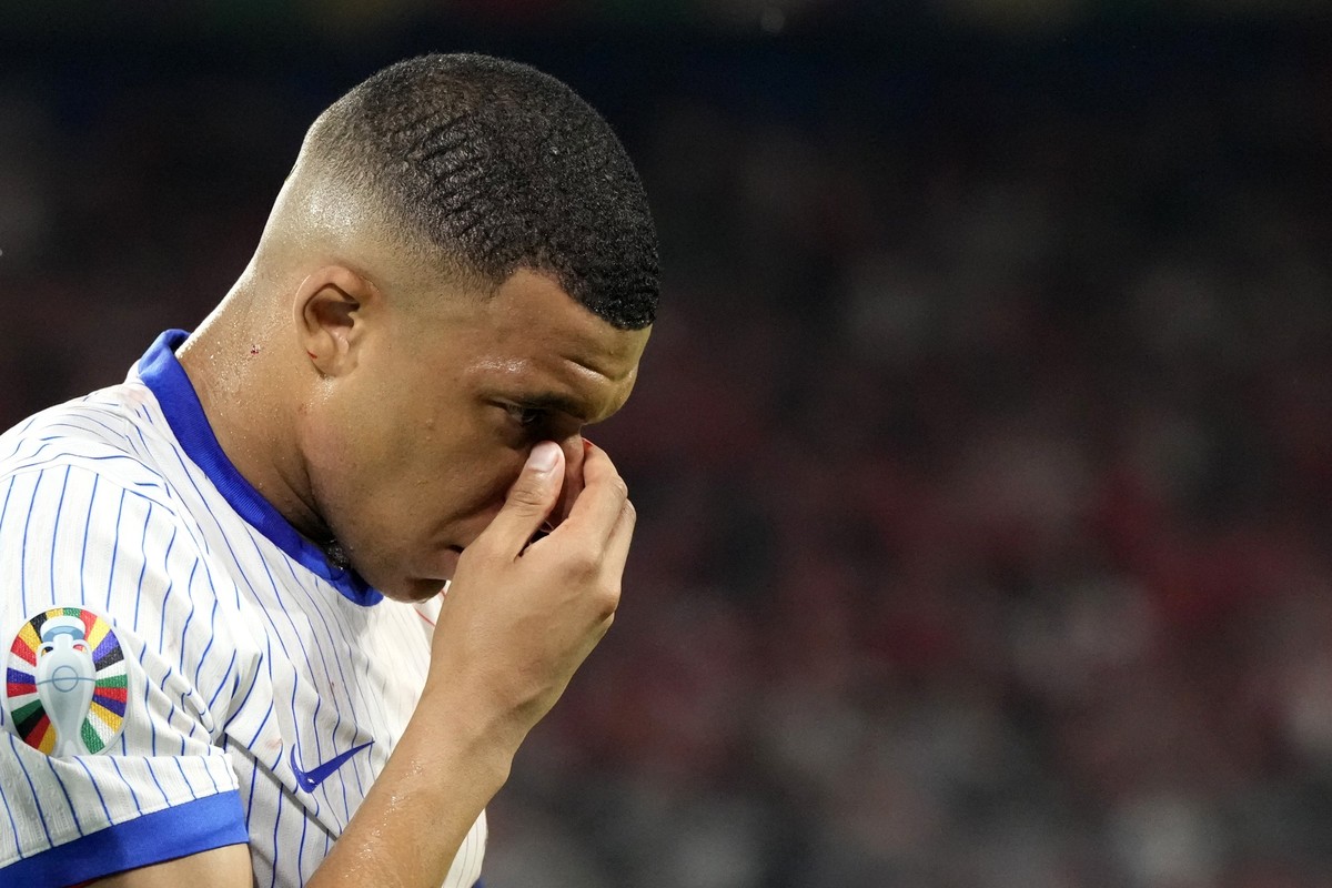 FILE - Kylian Mbappe of France holds his nose after suffering an injury during a Group D match between Austria and France at the Euro 2024 soccer tournament in Duesseldorf, Germany, Monday, June 17, 2 ...