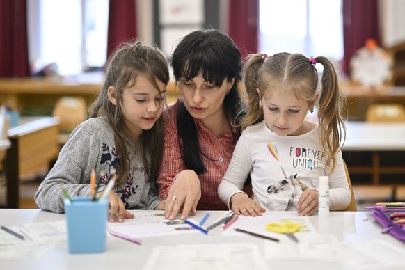 Die ukrainischen Fluechtlingskinder Veronika, links, und Alina, mit Lehrerin Alina Tochenyuk im Unterricht, aufgenommen im Rahmen eines Besuches fuer Medien am Freitag, 13. Mai 2022, im Schulhaus Land ...