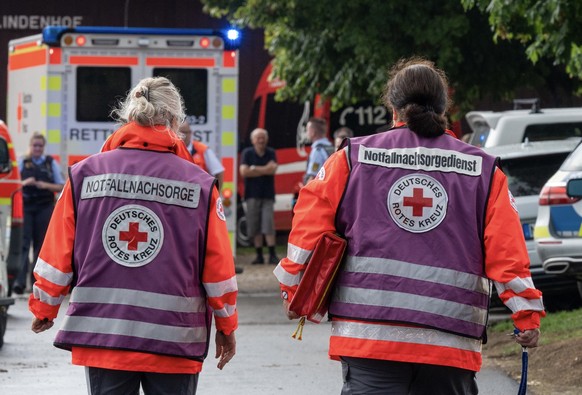 12.08.2023, Baden-Württemberg, Unterensingen: Notfallseelsorger gehen in der Nähe der Unglücksstelle. Beim Einschlag eines Blitzes in einen Baum sind sechs Menschen verletzt worden, drei davon lebensg ...