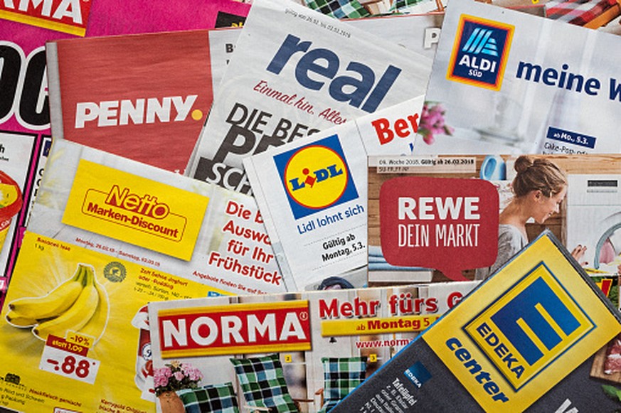 Amberg, Germany - February 26, 2018: Advertising leaflets of some German supermarket chains. Logos and brands are visible. Lidl, Aldi Süd, Penny Markt, Norma, Netto, Edeka, Real, Rewe.