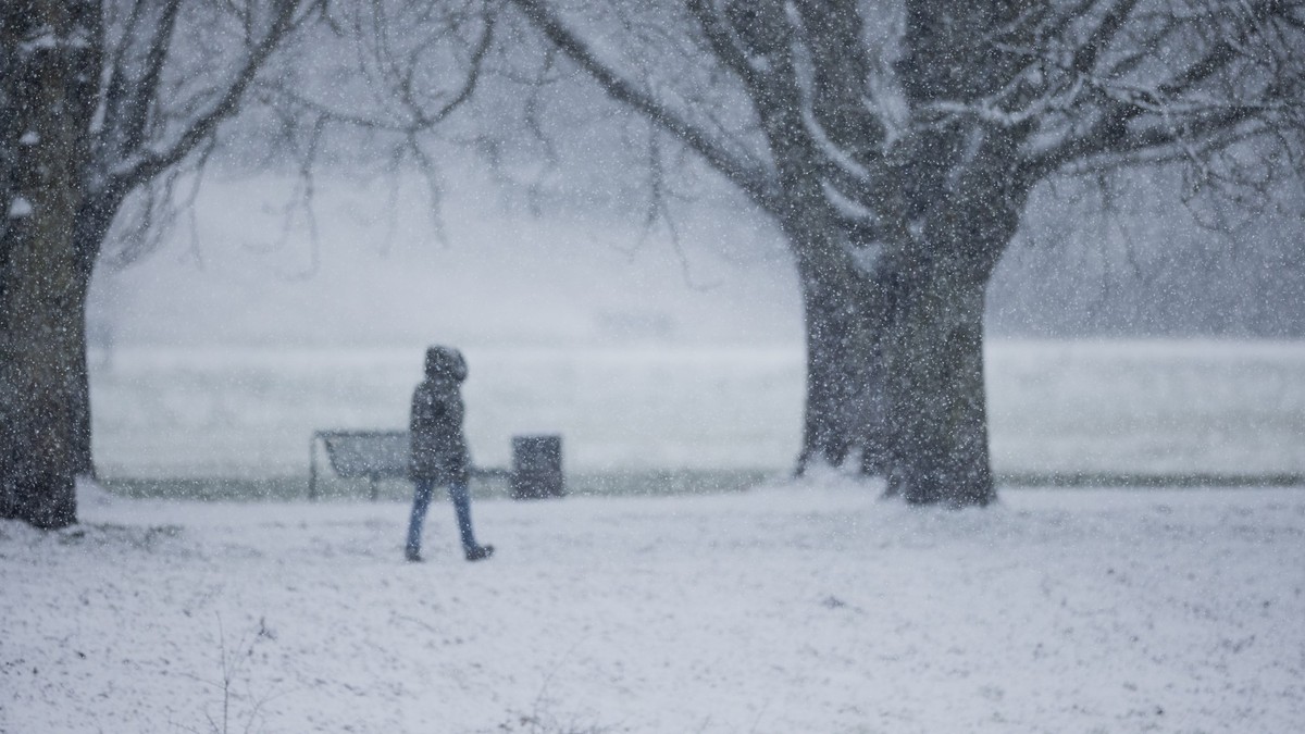 17.01.2024, Nordrhein-Westfalen, K�ln: Eine Person geht im dichten Schneetreiben am Decksteiner Weiher spazieren. Schnee und Eis haben Stra�en und Gehwege in weiten Teilen Deutschlands in gef�hrliche  ...