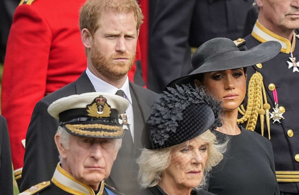 FILE - Britain's King Charles III, from bottom left, Camilla, the Queen Consort, Prince Harry and Meghan, Duchess of Sussex watch as the coffin of Queen Elizabeth II is placed into the hearse fol ...