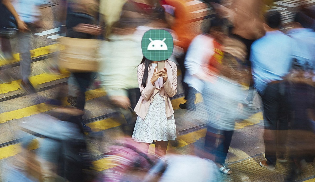 High angle view of young professional using mobile phone amidst crowd. Businesswoman is standing on busy street. She is surrounded by people in city.