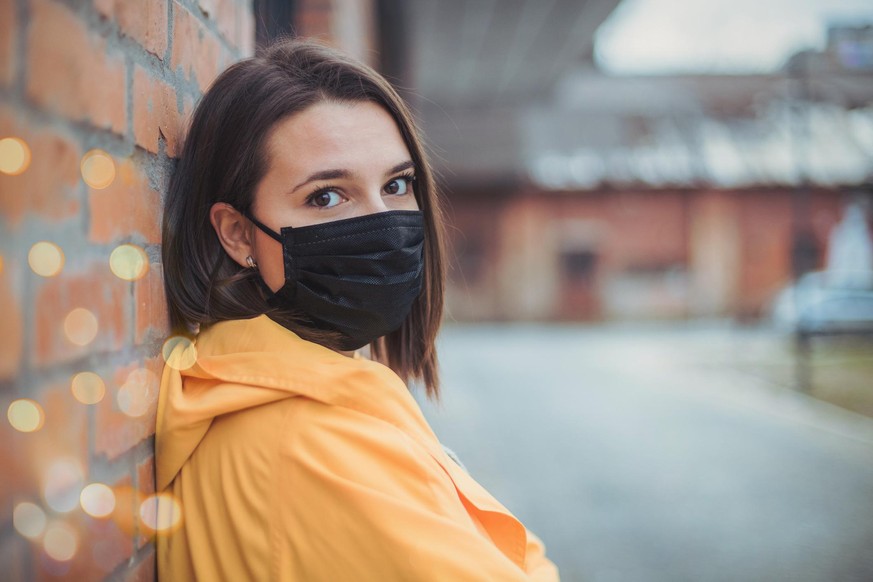 Junge Frau trägt Maske gegen Corona.