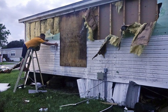 Ivan Mendoza begins to repair damage at his mobile home in Davie, Fla., early Wednesday, Sept. 28, 2022. Hurricane Ian rapidly intensified off Florida's southwest coast Wednesday morning, gaining top  ...