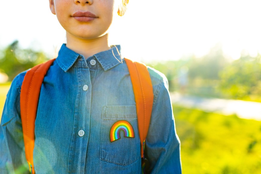 girl in denim t-shirt with rainbow symbol wear backpack in summer park outdoor.