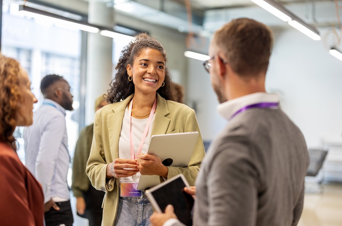 Diverse business people talking at the seminar. Group of man and women standing at the workshop and discussing at the office.