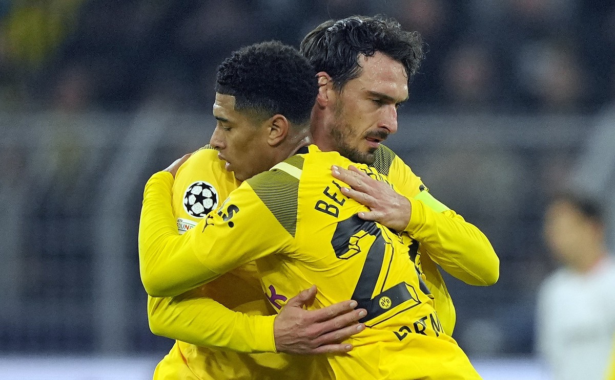 Dortmund's Mats Hummels, behind, celebrates Dortmund's scorer Jude Bellingham during the Champions League Group G soccer match between Borussia Dortmund and FC Sevilla in Dortmund, Germany, ...