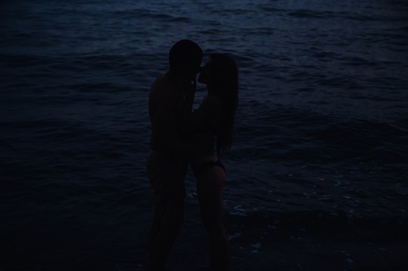 naked couple in love hugs and kisses in water in sea by beach on a summer night. Atmospheric lifestyle photography with soft focus and film grain Model Released Property Released xkwx couple, love, se ...